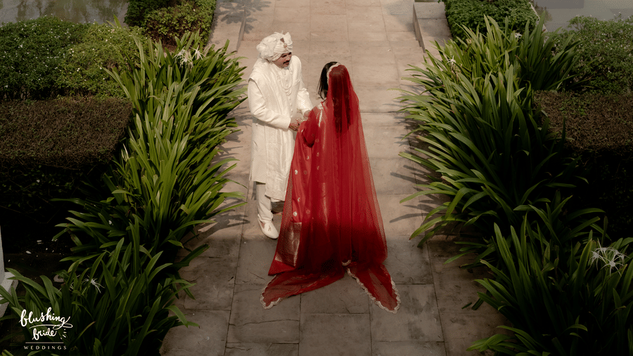 A married couple standing on the pathway set amidst the trees in Marasa Sarovar Premiere, Bodhgaya.