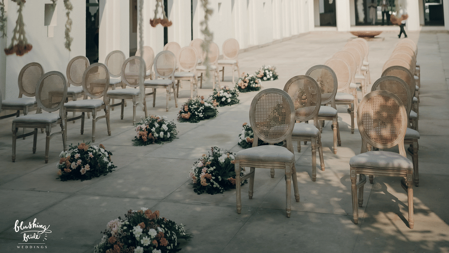 A wedding lawn at at Marasa Sarovar Premiere Bodhgaya featuring chairs, bouquets, and other decorative elements.