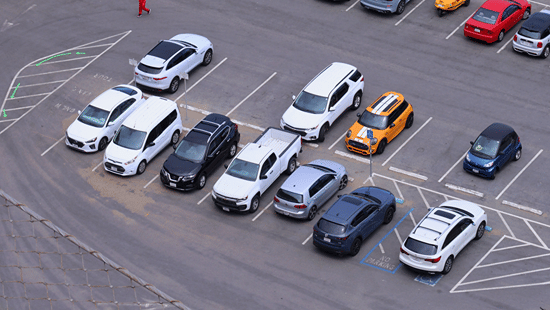 Cars parked along a coastal road overlooking the sea.