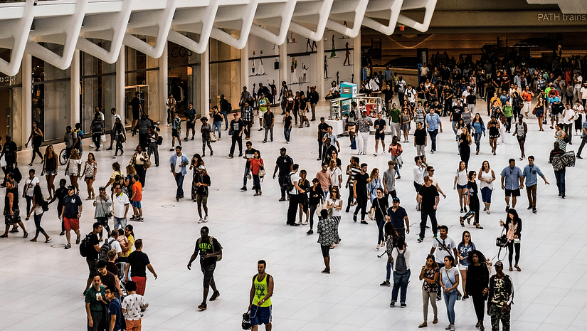 a Crowd walking at a convention centre with a building next to them