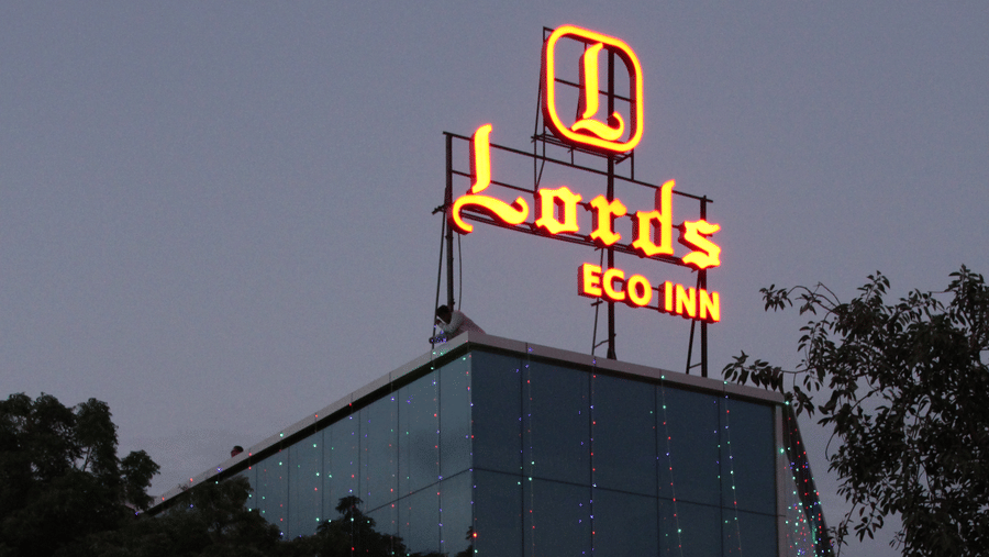 Hotel exterior at night with signage and cars parked outside