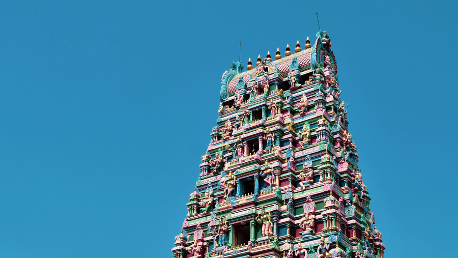 A far-out view of a temple in South India featuring Dravidian architecture of different Hindu deities on the Gopuram.