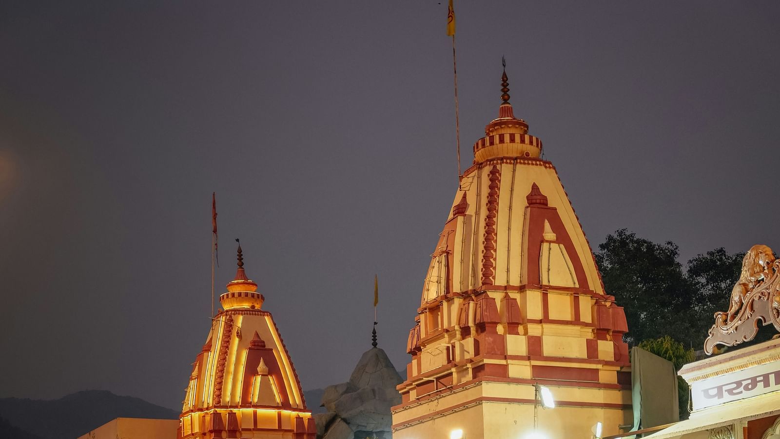 A crowded ashram with people gathered near the entrance.