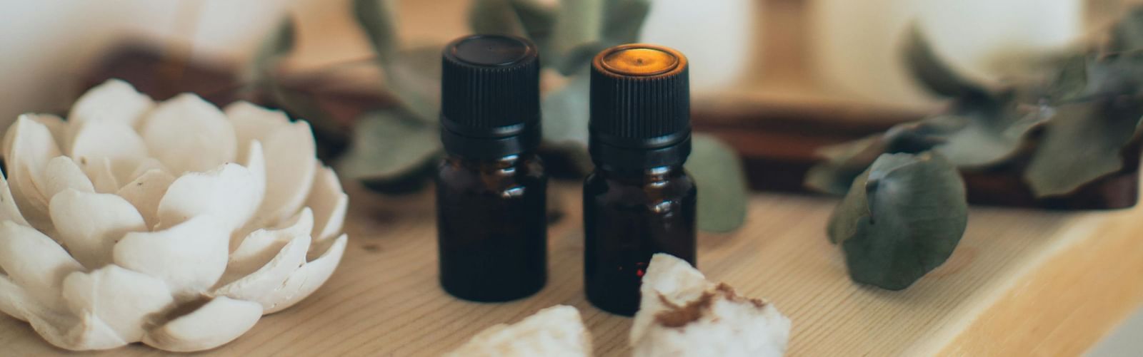 A spa setting with candles, incense sticks, and essential oils placed on a table.