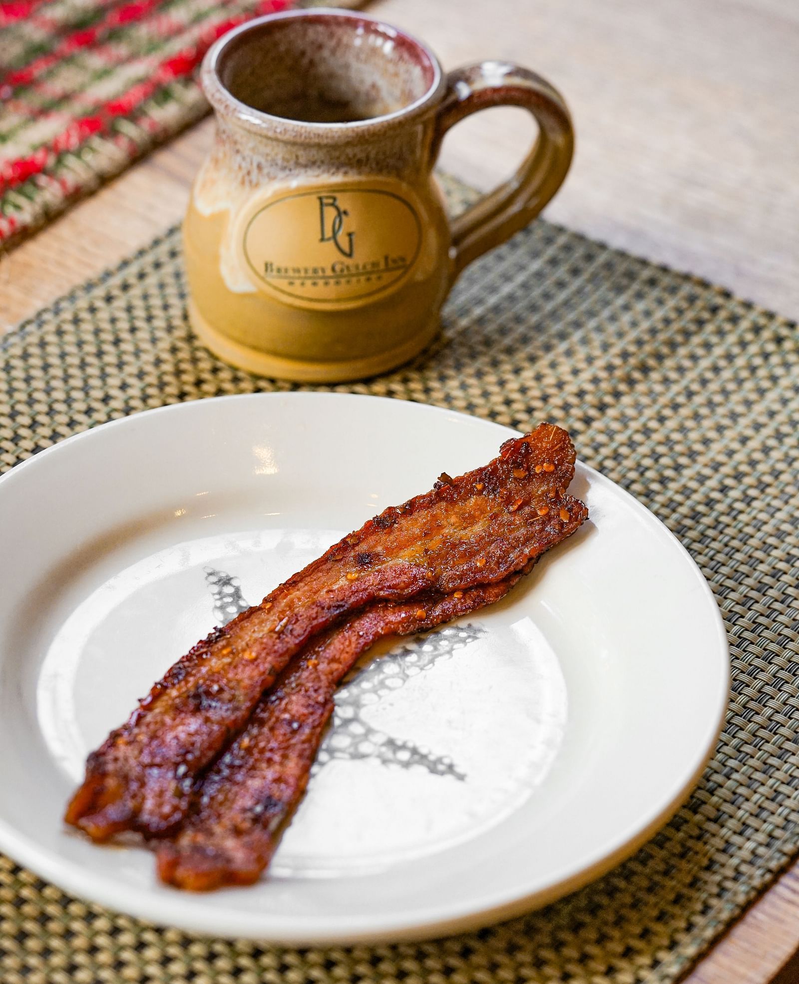 Crispy, perfectly cooked bacon served alongside a fresh cup of coffee - Brewery Gulch Inn & Spa