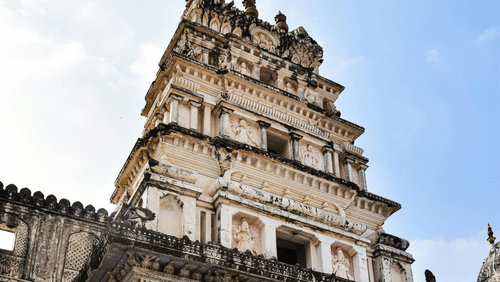 The facade of a temple featuring intricate carvings, a grand entrance, and a towering spire, showcasing traditional architectural details.