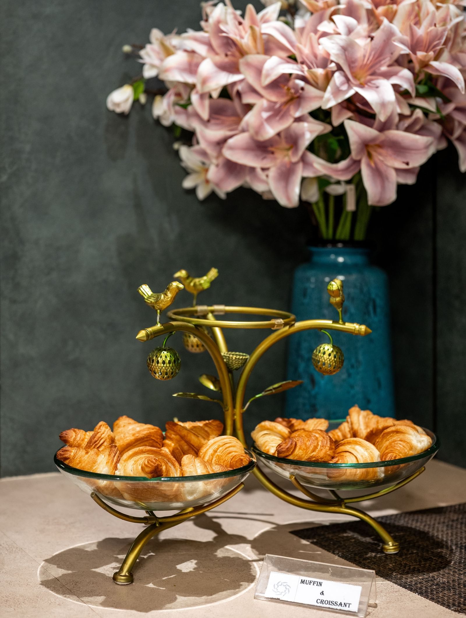 Flower arrangement with croissant displayed on a stand at Hotel Royal Regency Chennai