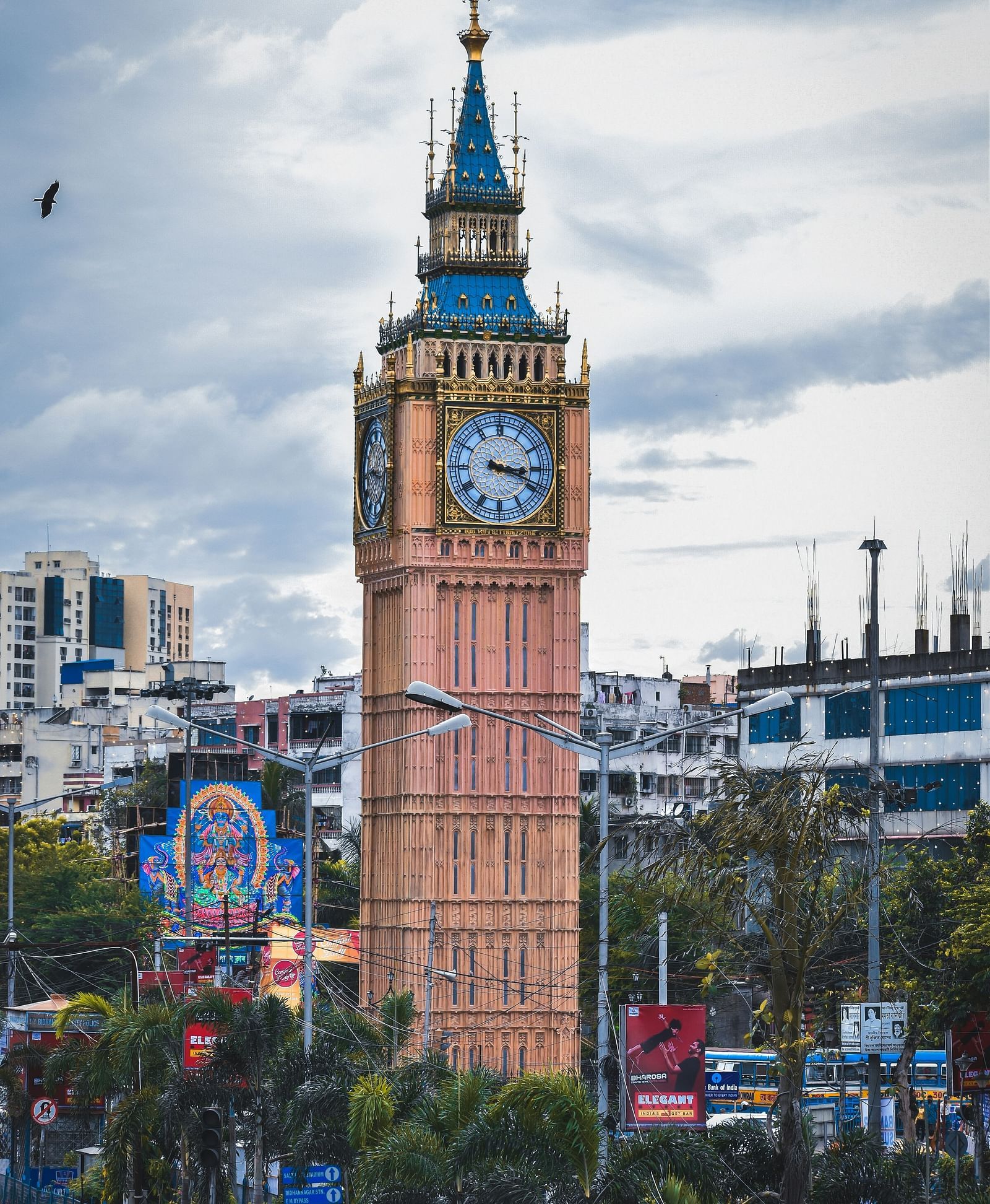 A replica of the Big Ben clock tower juxtaposed against a city scape, with an Indian motif in the foreground