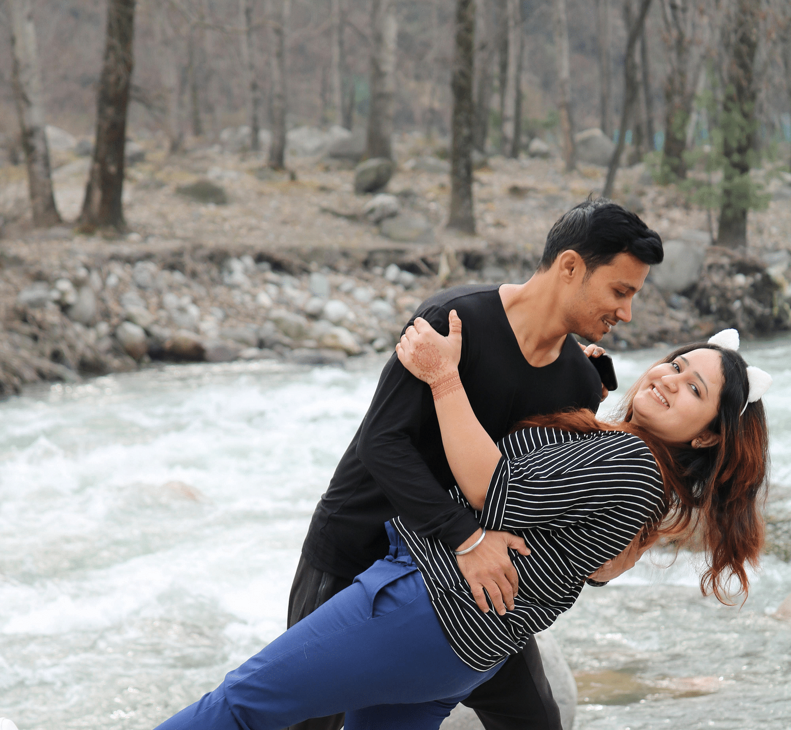 image of a couple posing for a photo besides a stream of river