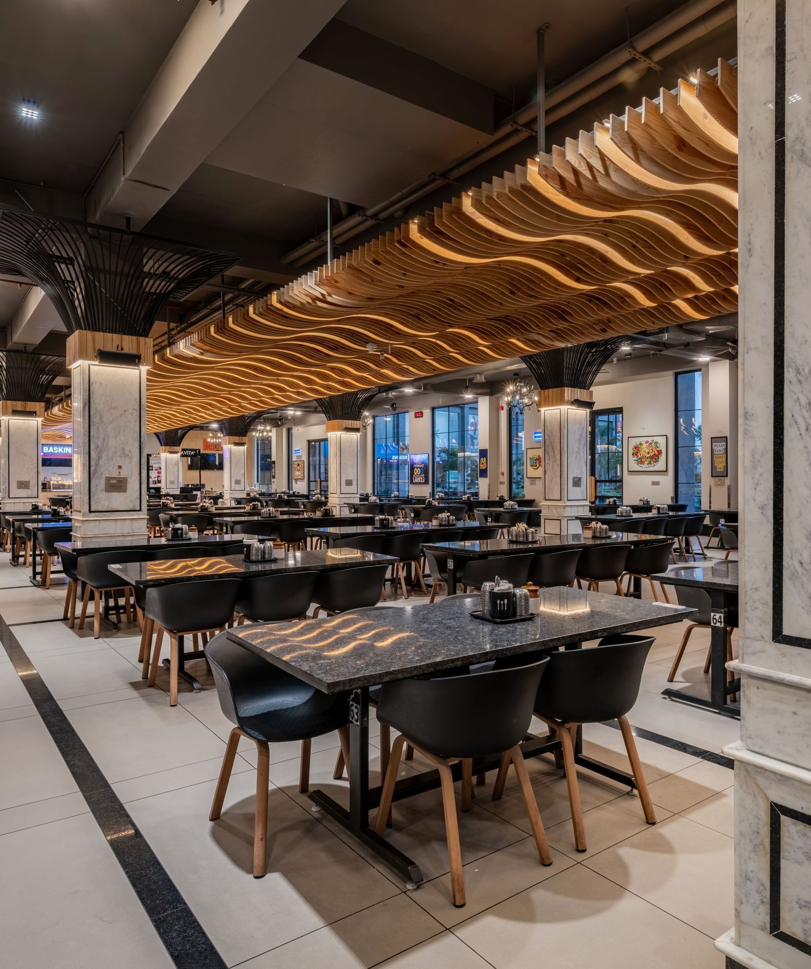 Indoor restaurant seating with tables and ceiling lights at Hotel Highway King, Kishangarh.