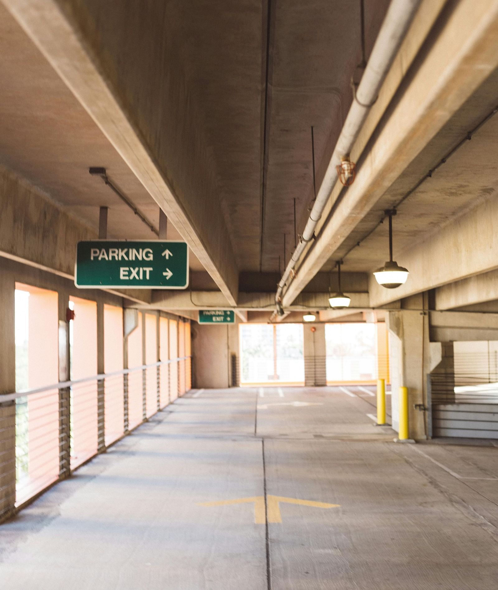 An overview of an empty parking lot with a sign on the left hand side.