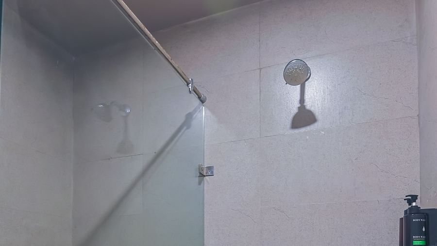 Shower and toilet area in a compact bathroom at Max Hotel Prayagraj.