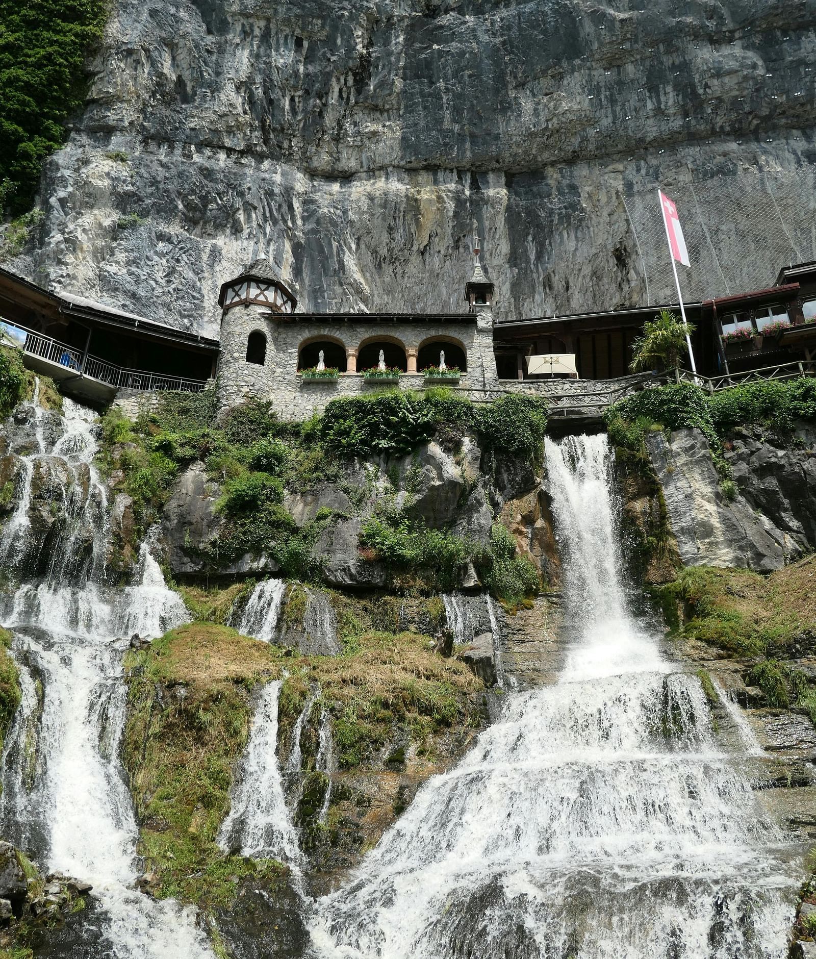 Waterfalls cascading sown the caves  surrounded by greenery