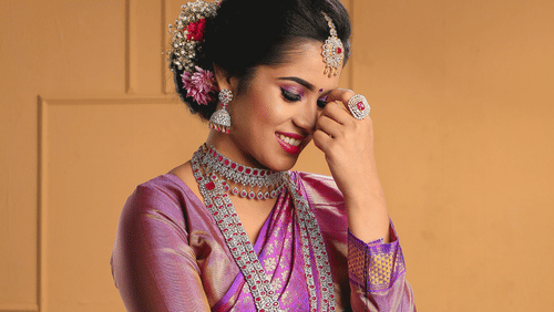A woman dressed as a bride with many jewelleries posing for a picture.