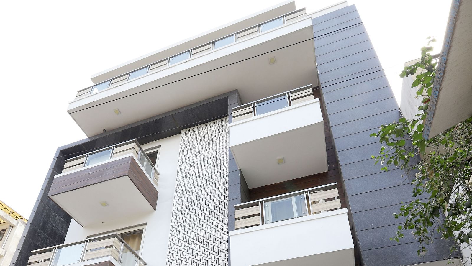 A contemporary building with a unique stacked design and balconies is viewed from a low angle - Asian Suites Cyber Park, Gurgaon