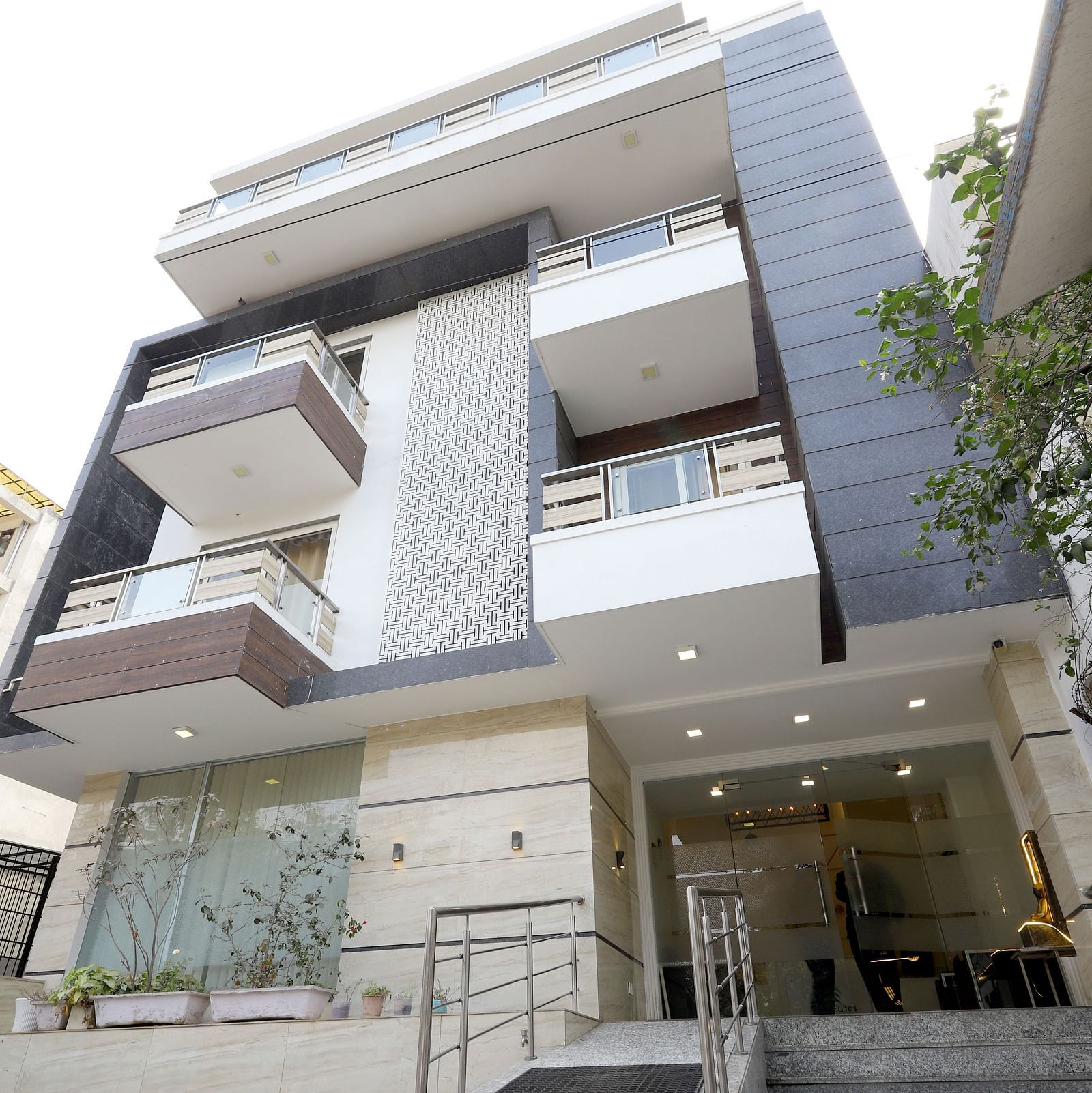 A contemporary building with a unique stacked design and balconies is viewed from a low angle - Asian Suites Cyber Park, Gurgaon