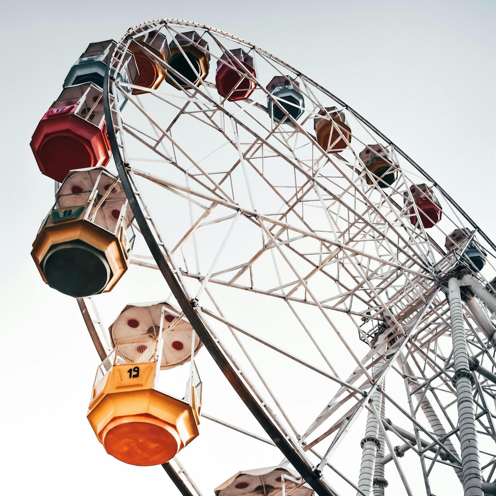 Ferris wheel with passengers seated in gondolas against a clear sky