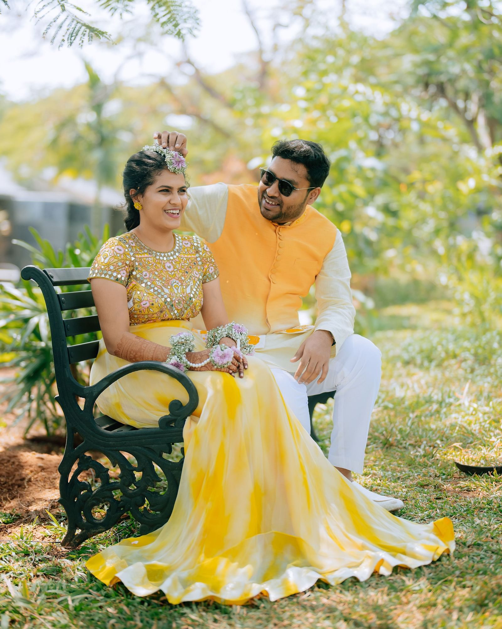 image of the bride and groom sitting together at a bench in the garden at darza resorts - coimbatore luxury resort