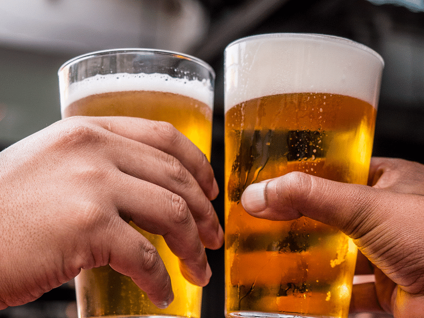 two-persons-holding-drinking-glasses-filled-with-beer-1089930