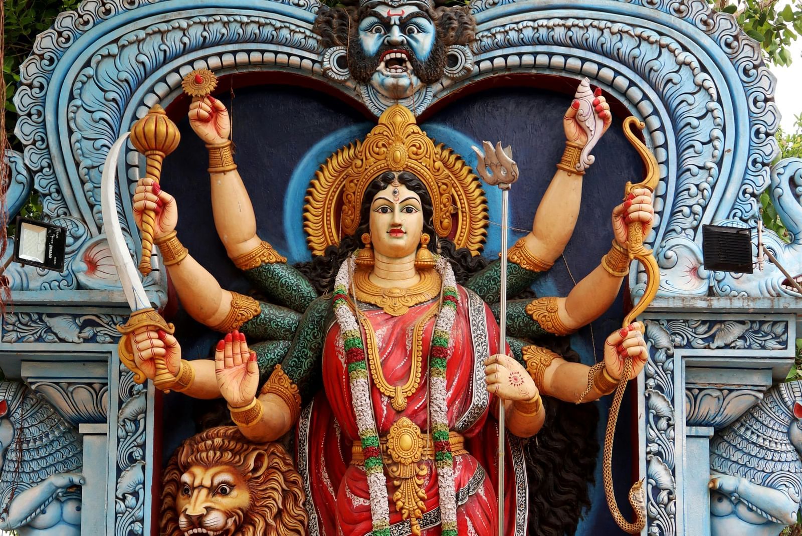 A statue of goddess Durga with a lion behind her.