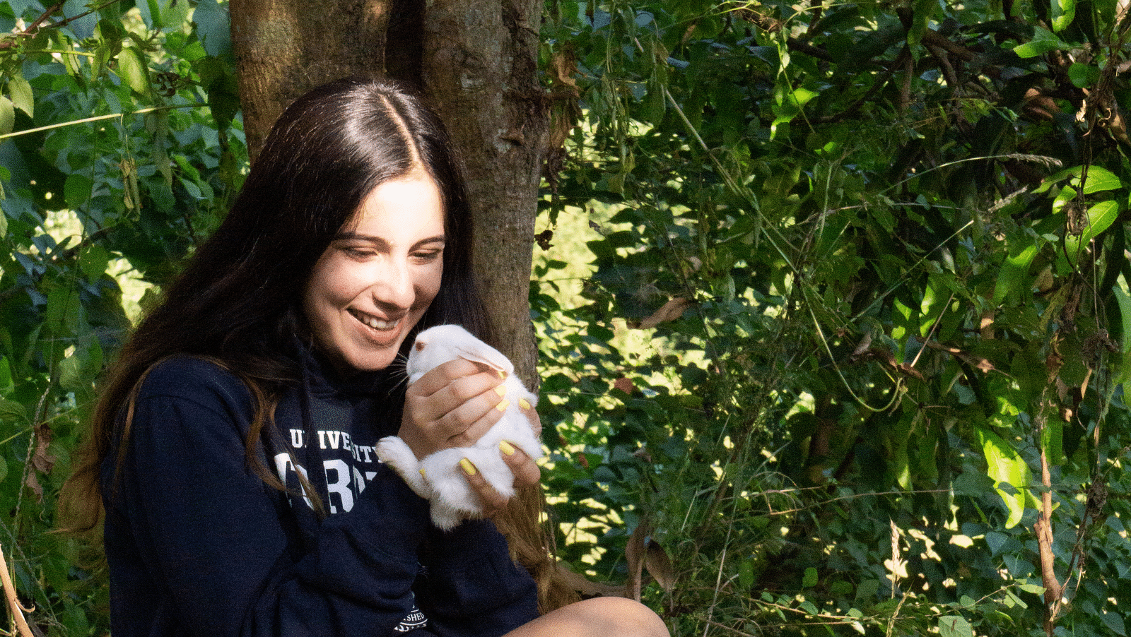 A woman petting a rabbit sitting on the cliff at the Sylvan Retreat, Dehradun.