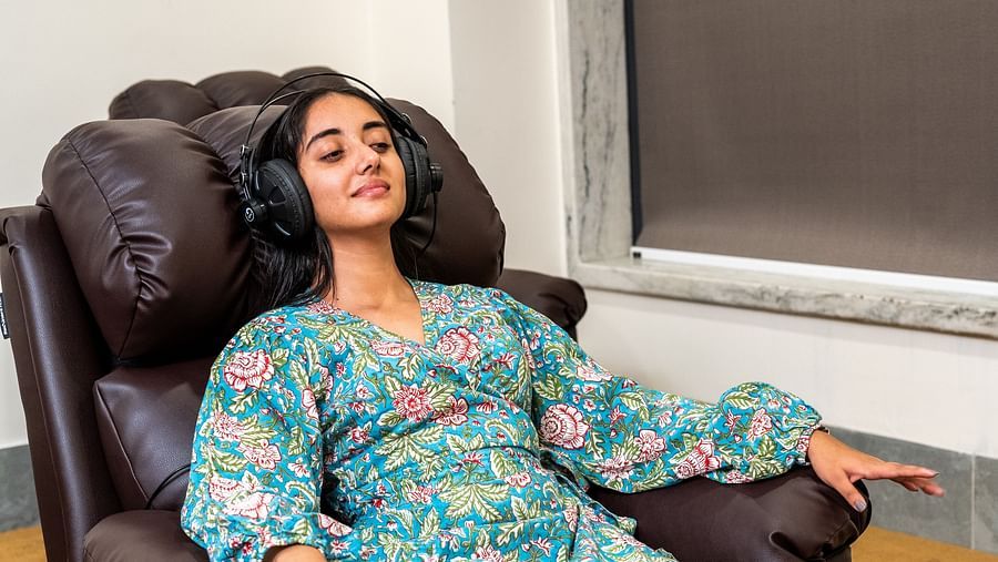 A patient listening to music on a cosy couch - Rajbagh Wellness, Udaipur