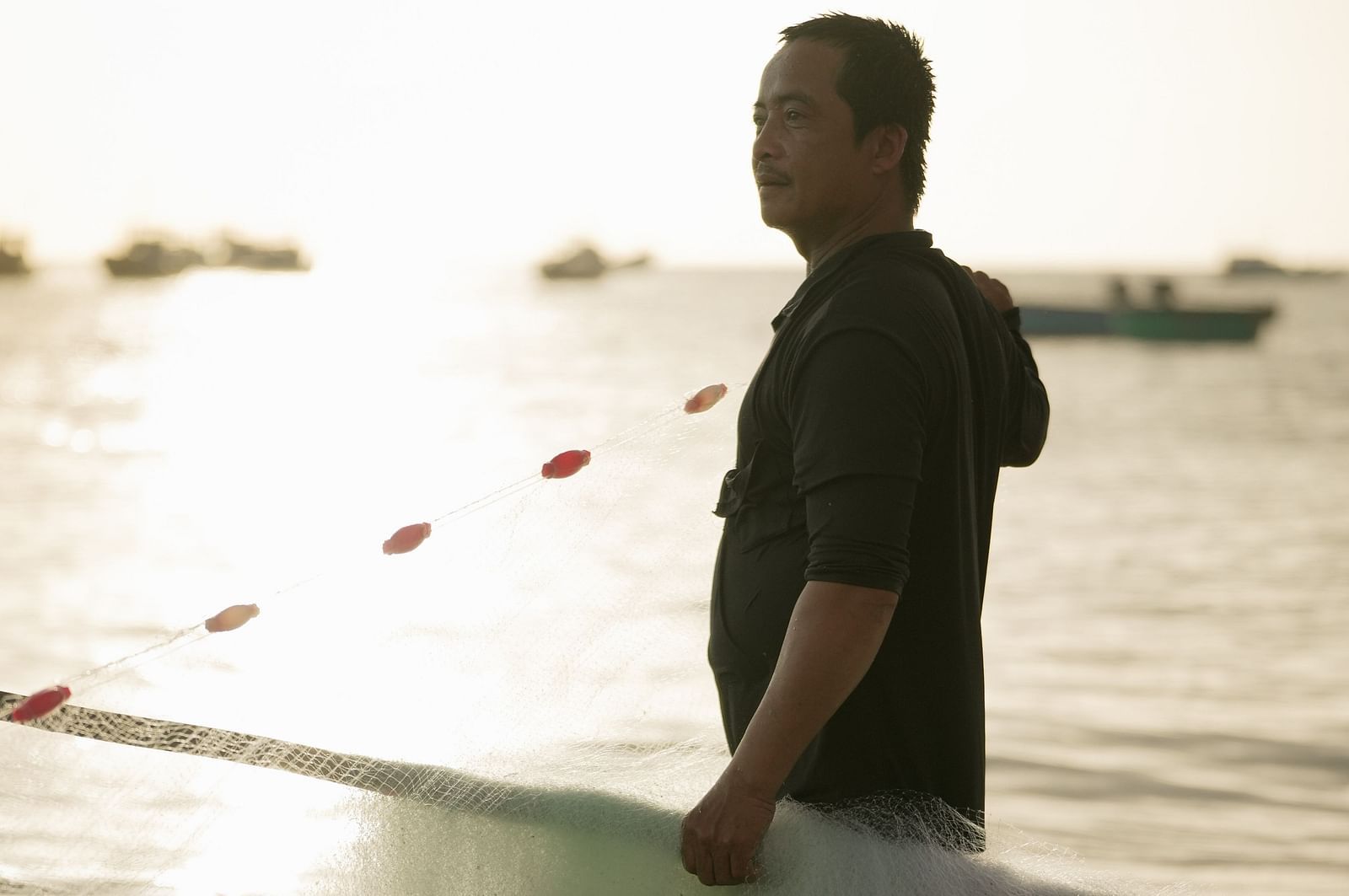 A fisherman standing with his net at the beach