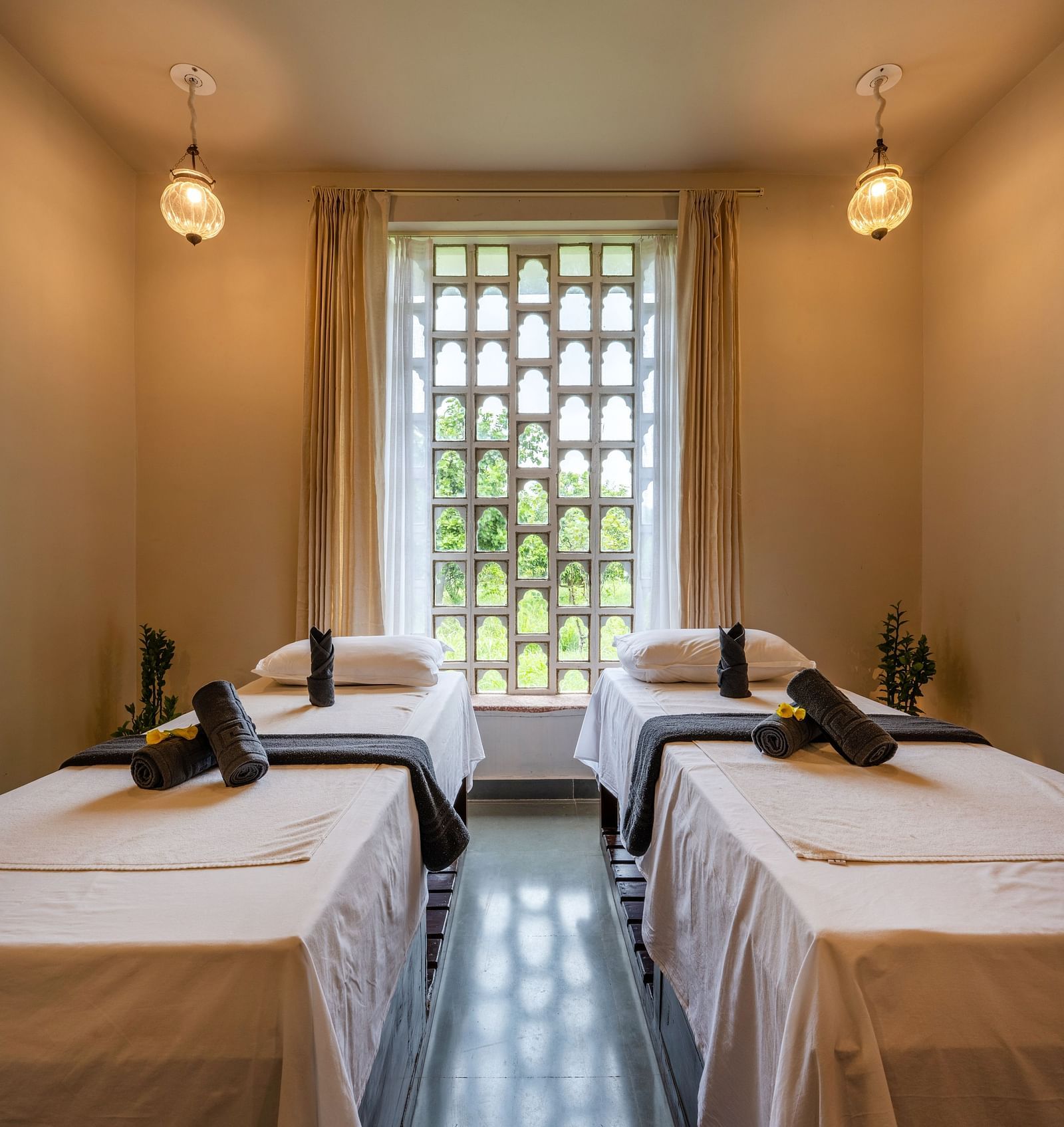 A close up shot of the beds in the spa with beds and ambient lighting - Utsav Camp