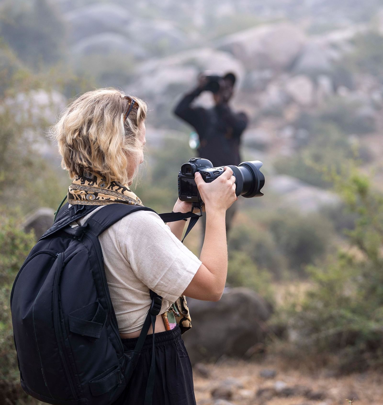 An image of a woman clicking pictures of the views with a camera - Utsav Camp Sariska