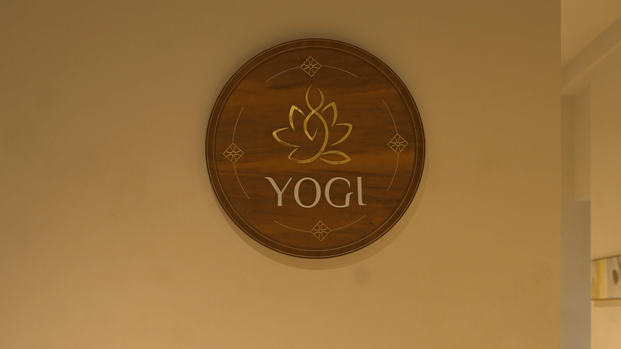 Wooden nameplate mounted near the restaurant entrance at Hotel Sonar Bangla, Mayapur.