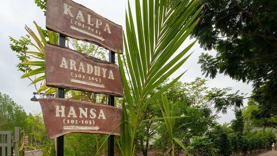 An image of a pathway with sign board and greenery around - Trance Veechika Resort, Vikarabad