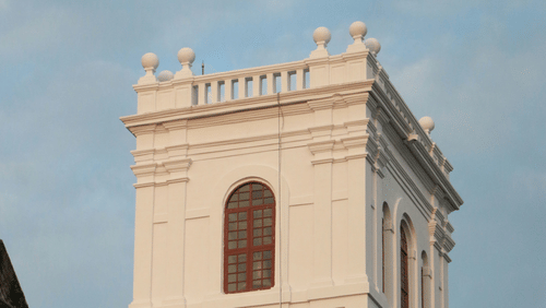 A white  tower, standing tall against a bright sky, representing the architectural heritage of the region