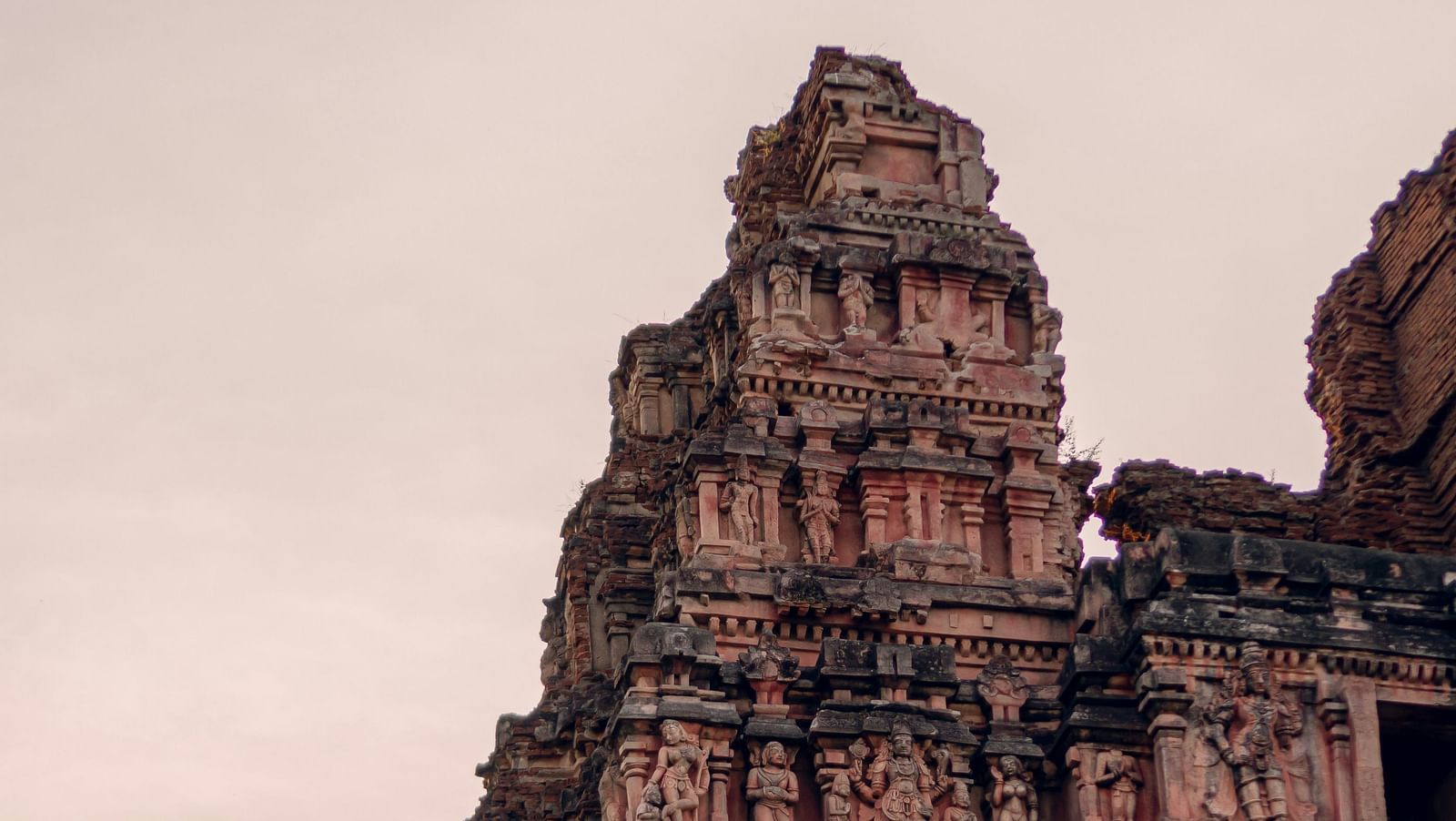 Ancient temple tower with ornate carvings against a dusky sky.