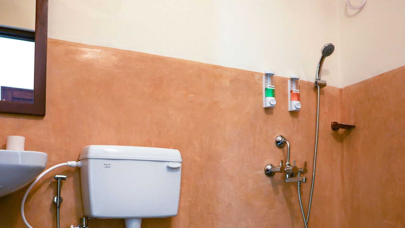 A western bathroom that has a commode, a sink, mirror on the wall, faucet, showerhead, etc | Mango Hill La Serene, Pondicherry