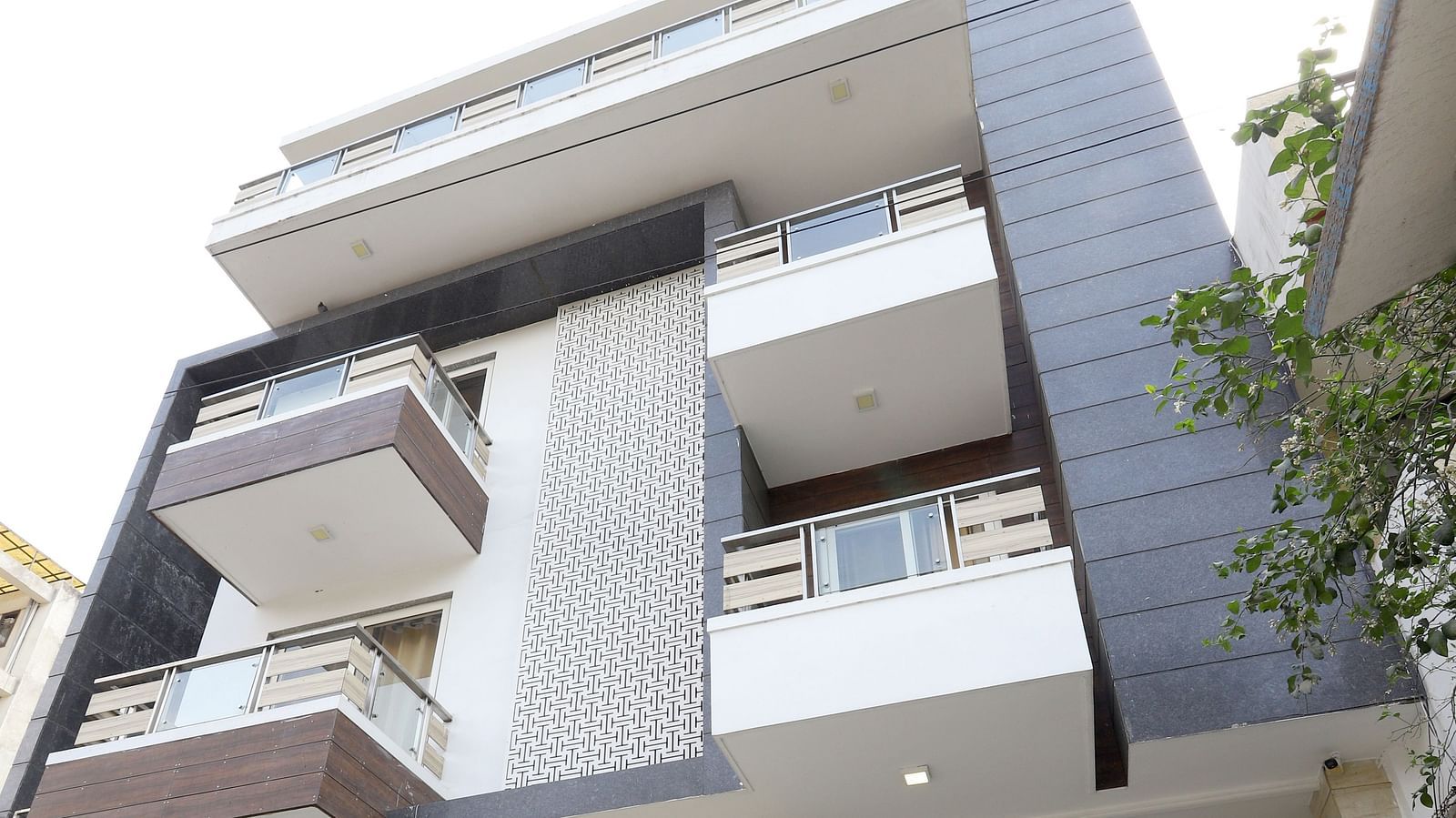 A contemporary building with a unique stacked design and balconies is viewed from a low angle - Asian Suites Cyber Park, Gurgaon