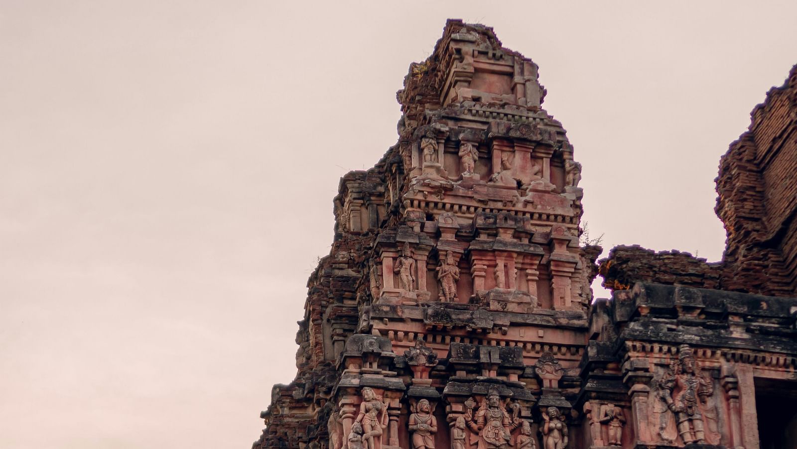 Ancient temple tower with ornate carvings against a dusky sky.
