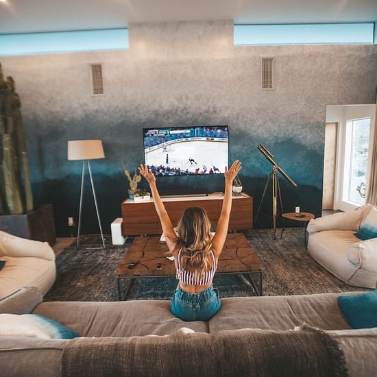 A woman watches TV in a living room