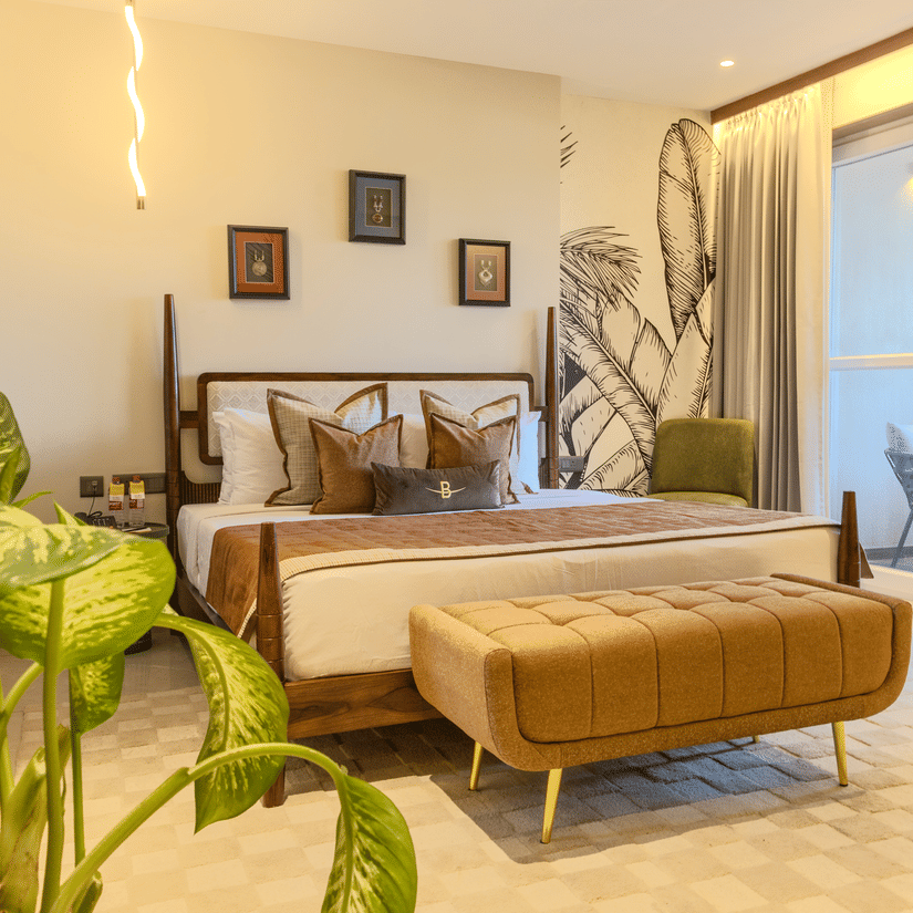 Neatly dressed bedroom with a cushioned bench at the foot of the bed and warm ambient lighting at Hotel Bawa, Udaipur
