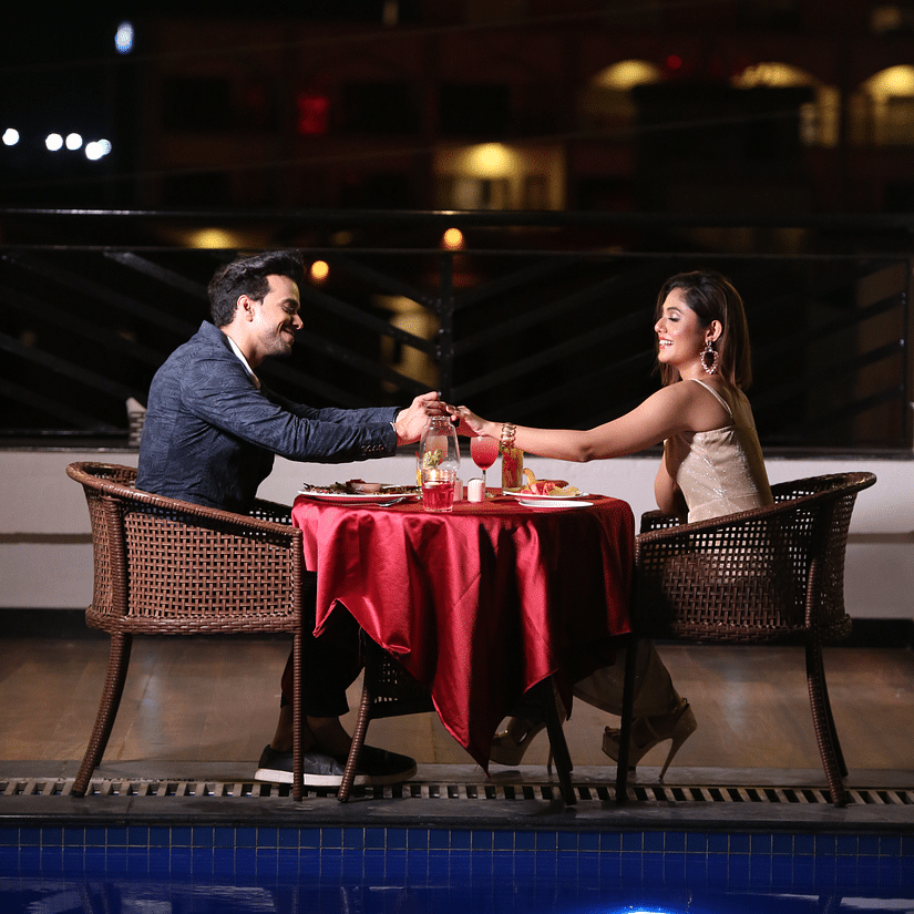 a romantic candlelight dinner for a couple who are seated next to the swimming pool - Shanti Seaview Resort & Spa