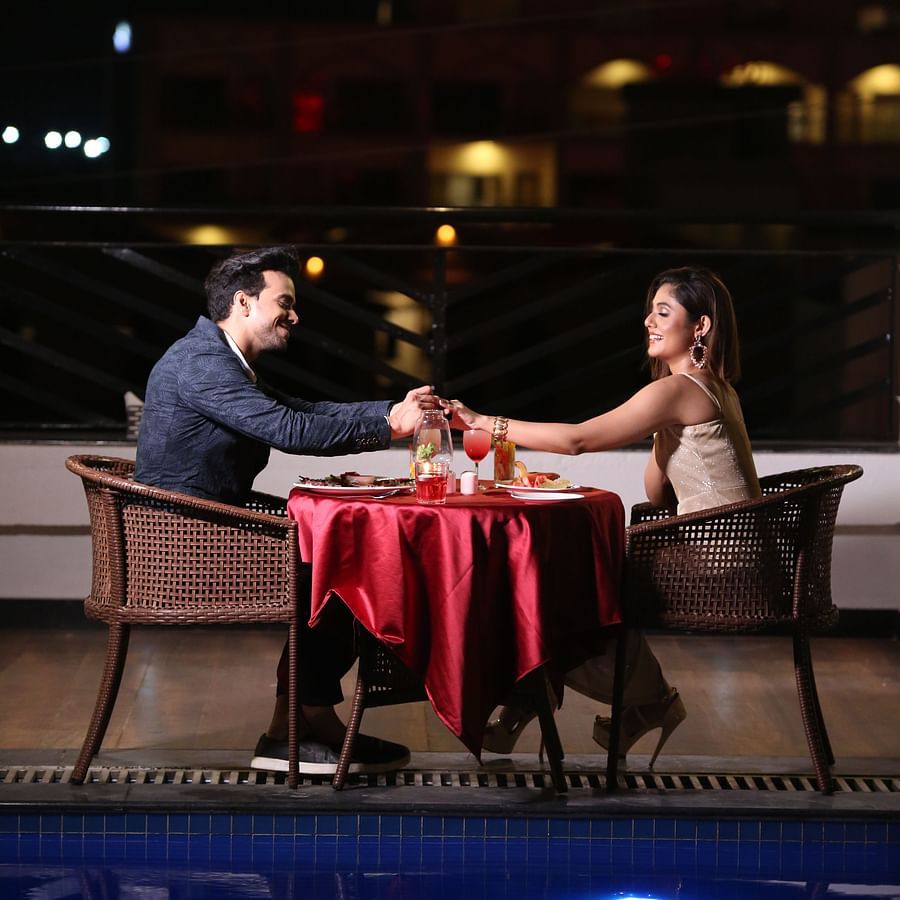 a romantic candlelight dinner for a couple who are seated next to the swimming pool - Shanti Seaview Resort & Spa