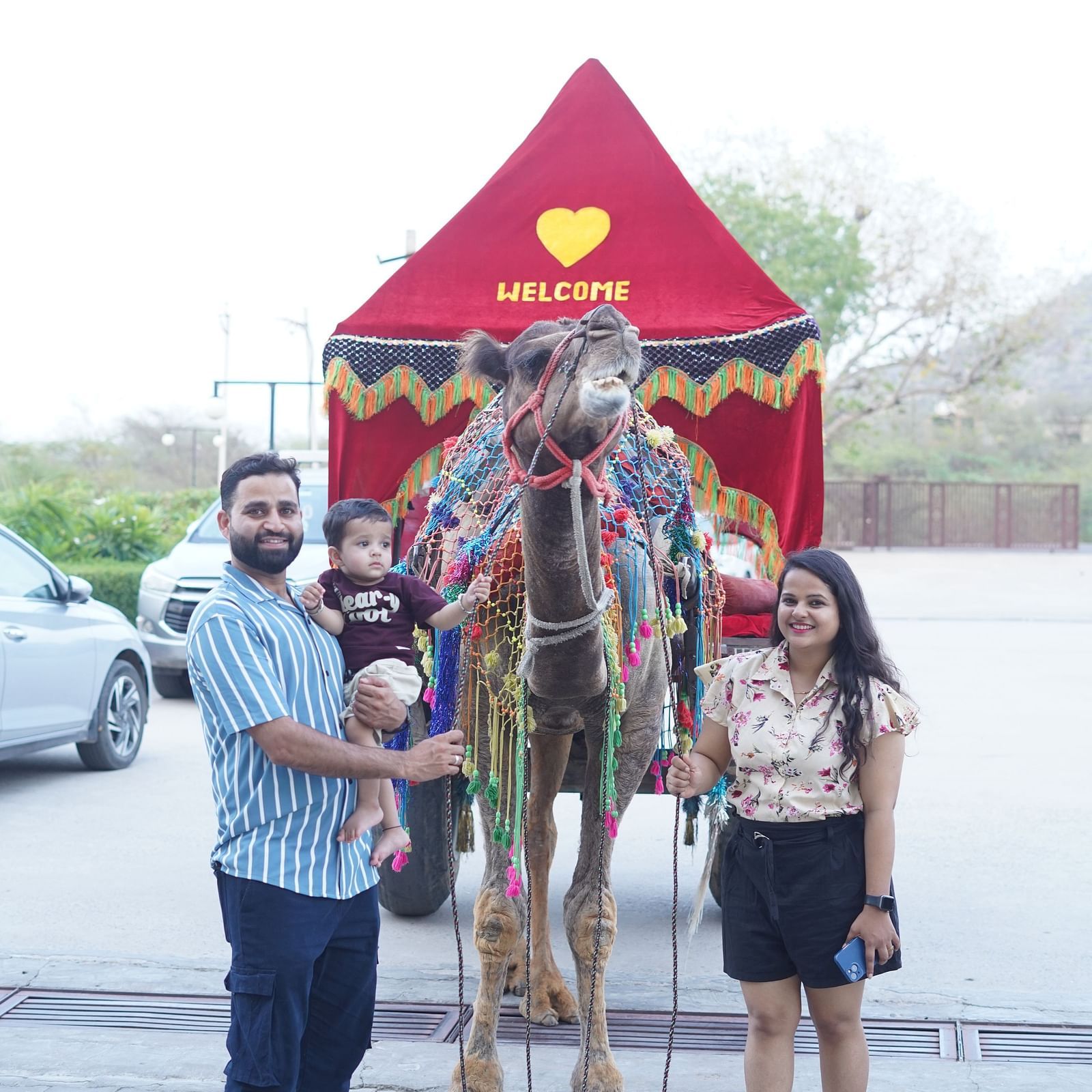 Two people standing with a kid in front of a camel cart - Bamboo Saa Mulberry Resort, Pushkar