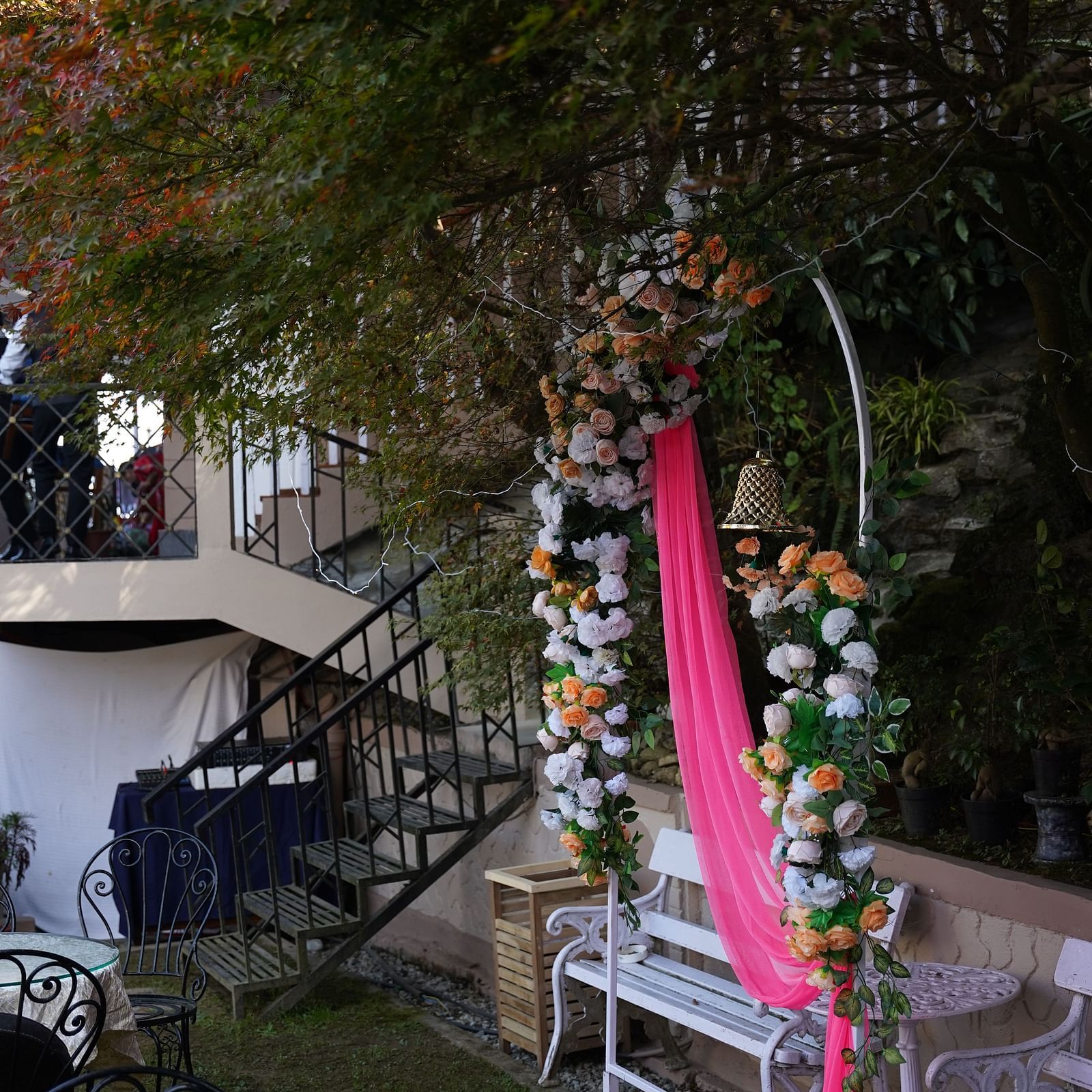 Portrait view of a photo bench designed with an arch and free-hanging fabric placed in the lawn area of Cedar Inn, Darjeeling.