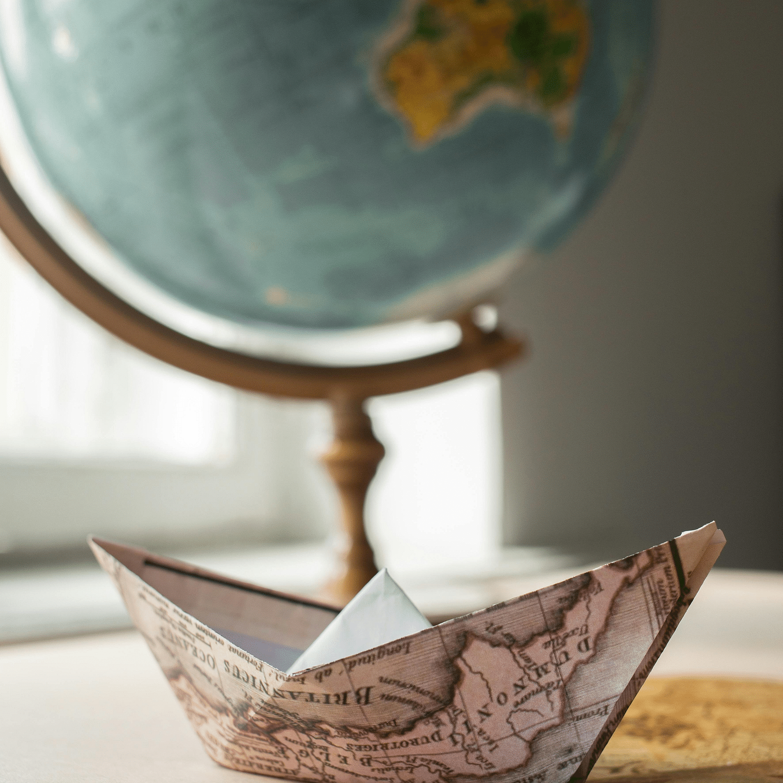 an image of a globe with a paper boat