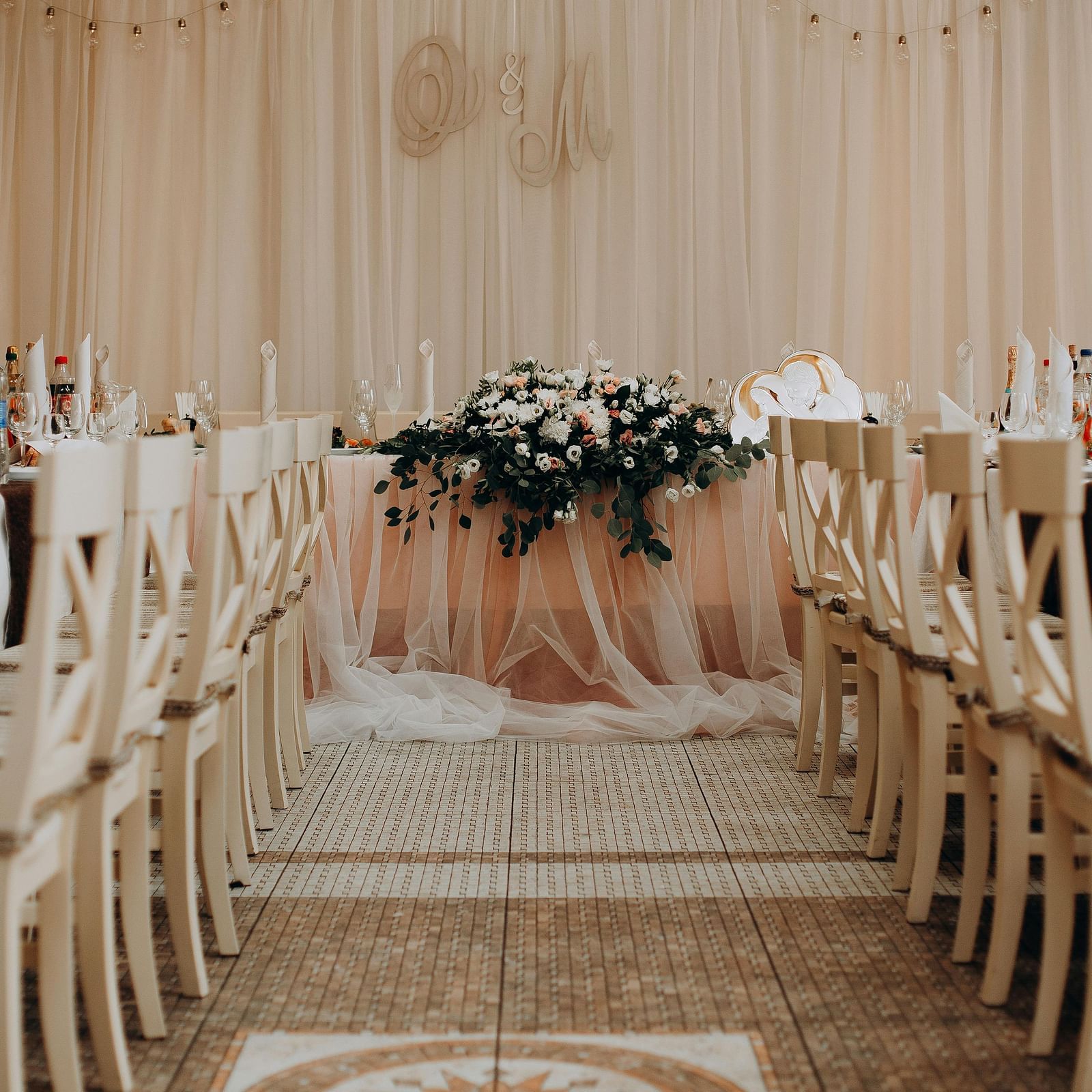 A beautifully decorated aisle leads to a stage in a wedding or event space at Lords Plaza Surat.
