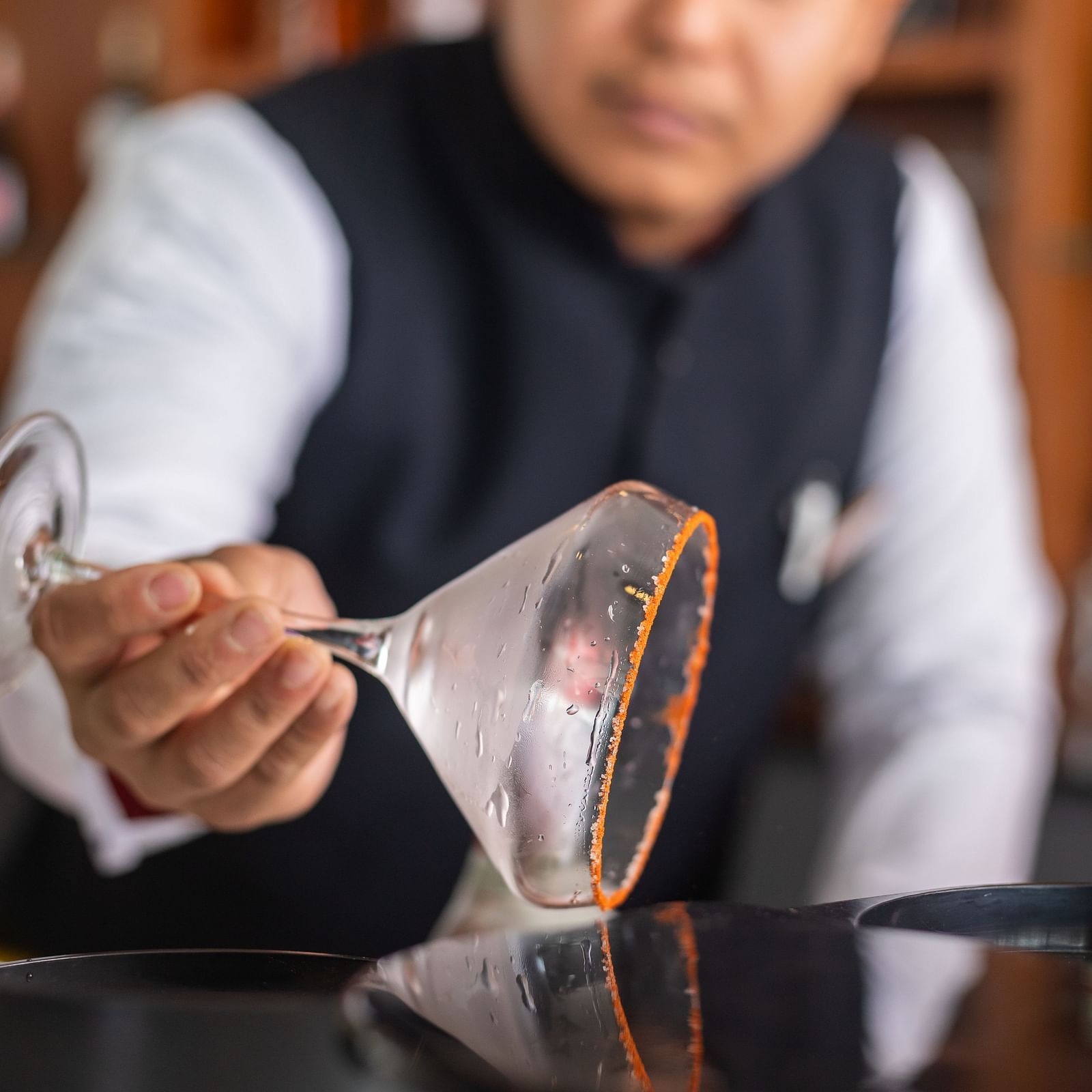 A bartender rimming a martini glass with a powder at Mandala Norling Lords Prime in Kathmandu.