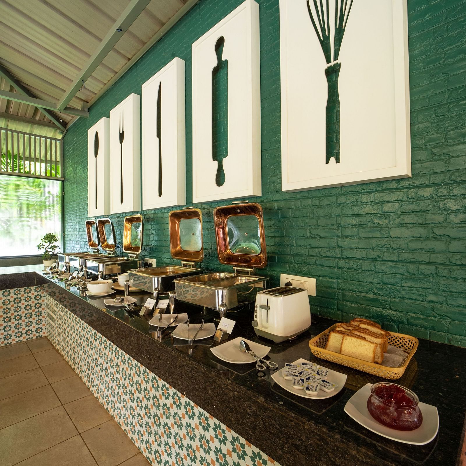 An image of the dining area with wall hanging images of kitchen utensils - Trance Veechika Resort, Vikarabad