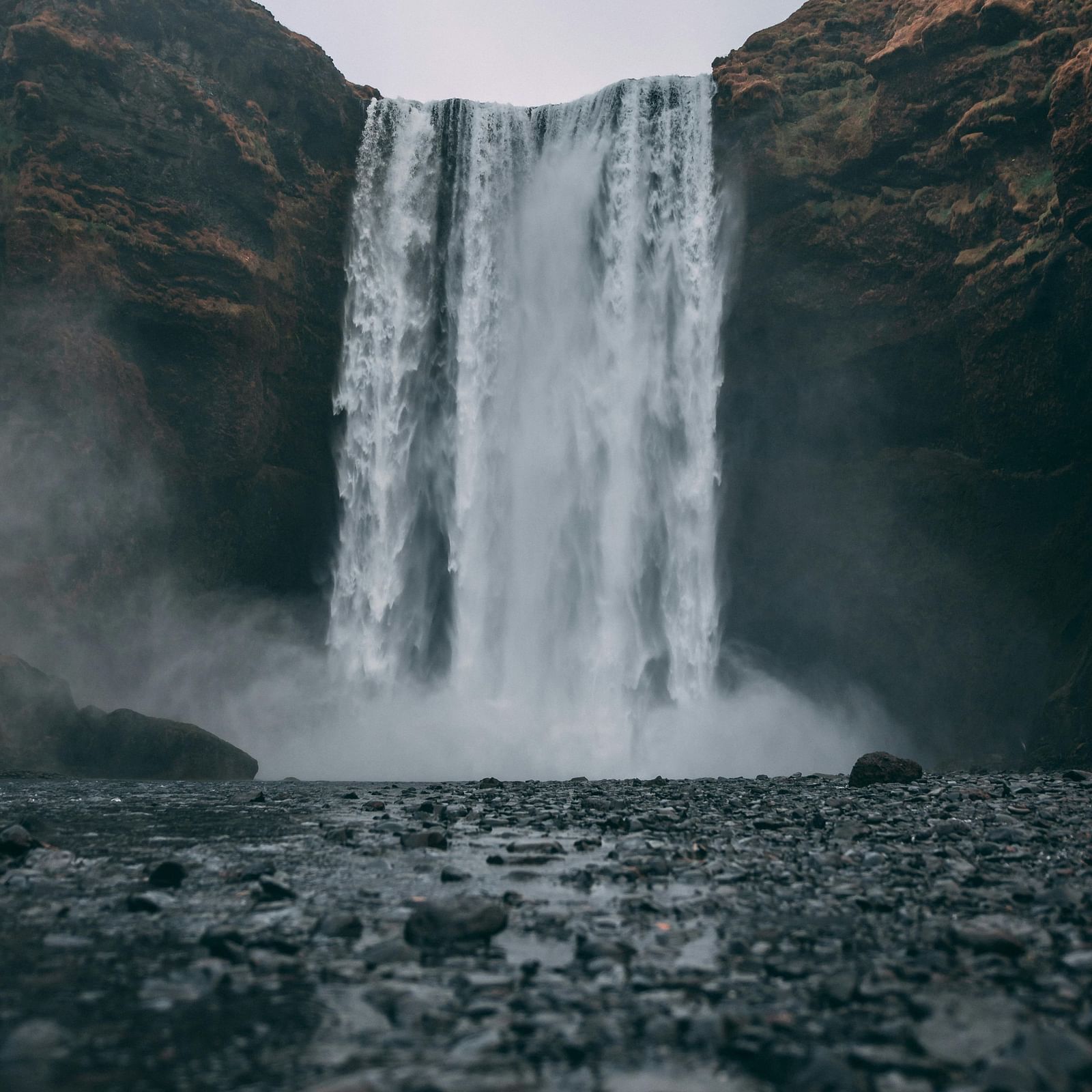 image featuring a beautiful waterfall falling from between two huge rock cliffs