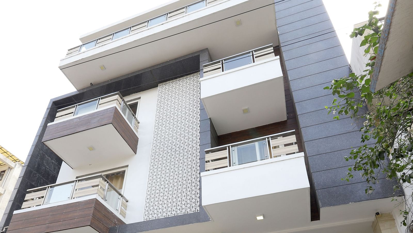 A contemporary building with a unique stacked design and balconies is viewed from a low angle - Asian Suites Cyber Park, Gurgaon