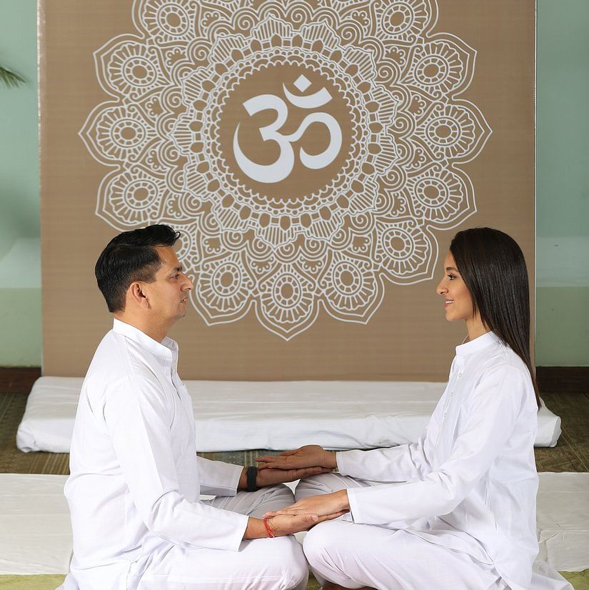 man and woman sitting and doing yoga