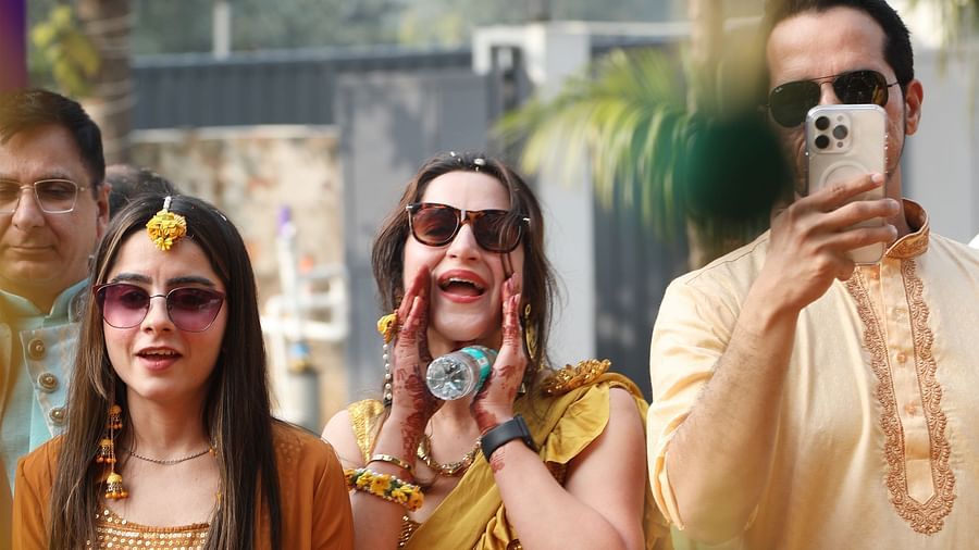 Group of three people in traditional clothes standing under a canopy at Tisya Farms, Gurgaon.